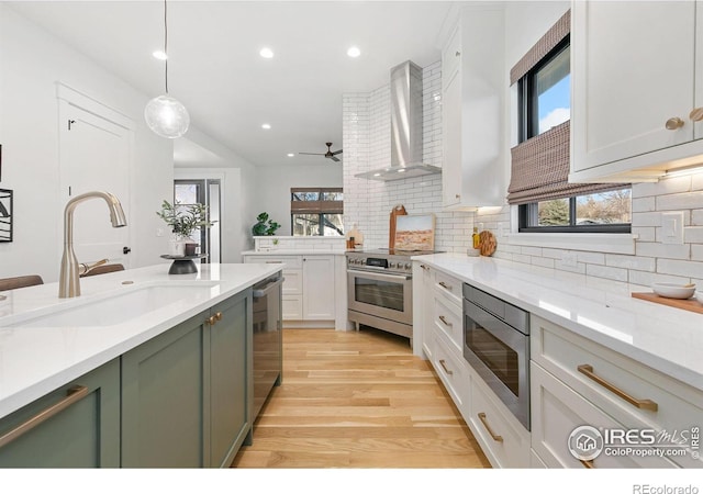 510 Wood St, Fort Collins, CO 80521 - kitchen featuring wall chimney range hood, appliances with stainless steel finishes, a sink, light wood-style flooring, and recessed lighting