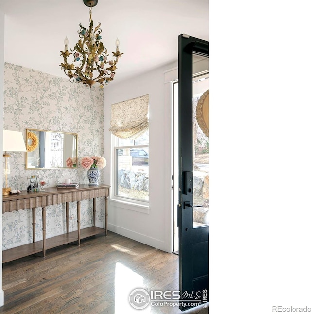 interior space with baseboards, an inviting chandelier, wood finished floors, and wallpapered walls