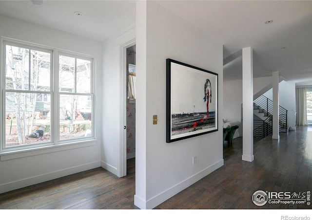 hall featuring stairs, wood finished floors, a wealth of natural light, and baseboards