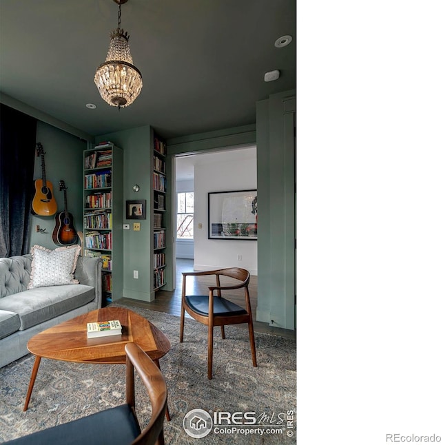 living area featuring an inviting chandelier, baseboards, and wood finished floors