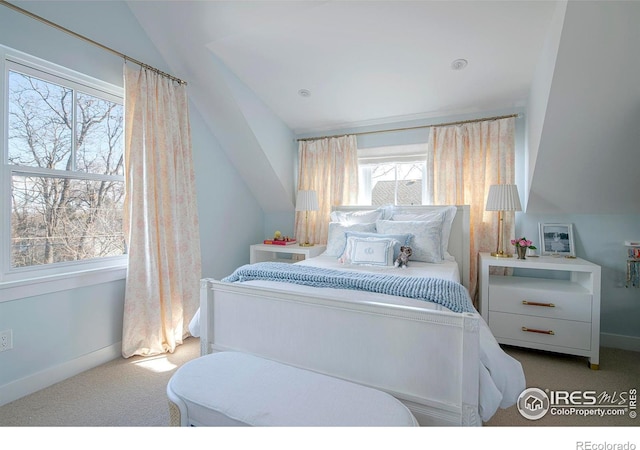 carpeted bedroom featuring lofted ceiling and baseboards