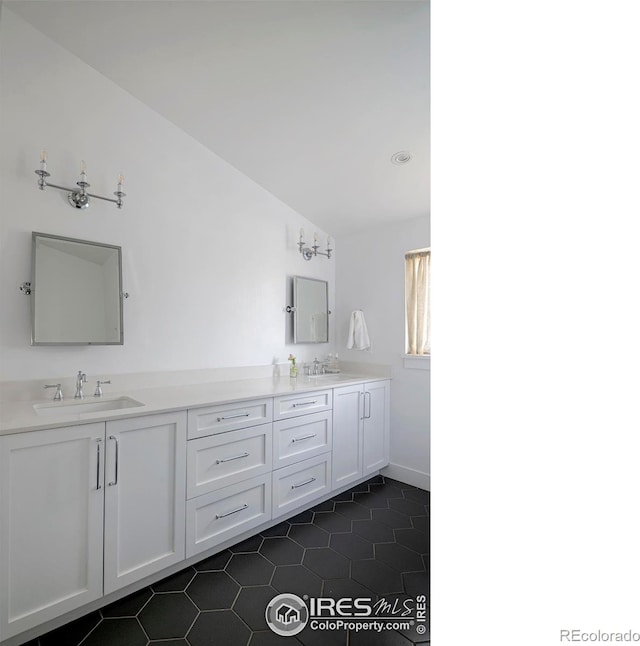 full bathroom featuring vaulted ceiling, double vanity, tile patterned flooring, and a sink