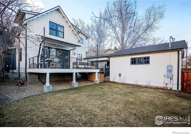 rear view of house featuring a yard and a wooden deck