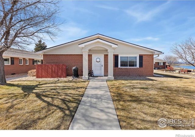 bungalow featuring brick siding and a front yard