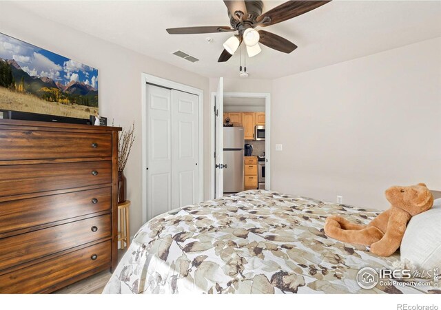 bedroom with visible vents, ceiling fan, a closet, and freestanding refrigerator