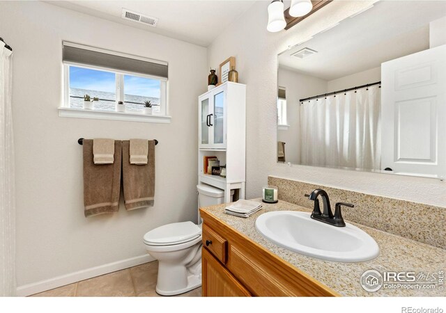 full bathroom with visible vents, vanity, toilet, and tile patterned floors