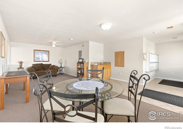 dining space with light tile patterned floors, a ceiling fan, and baseboards