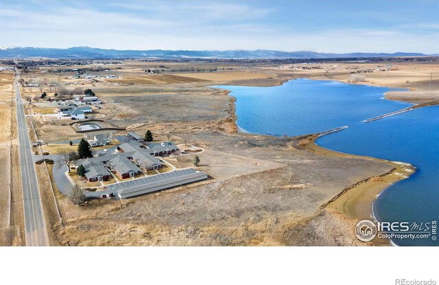 drone / aerial view featuring a water and mountain view