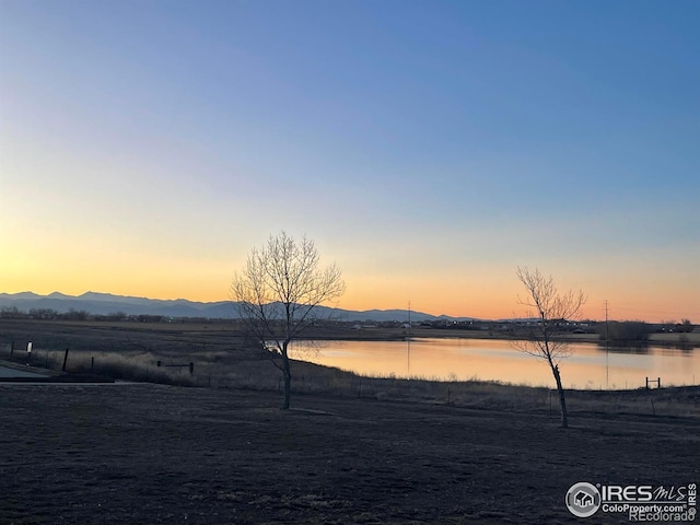 yard at dusk with a water and mountain view