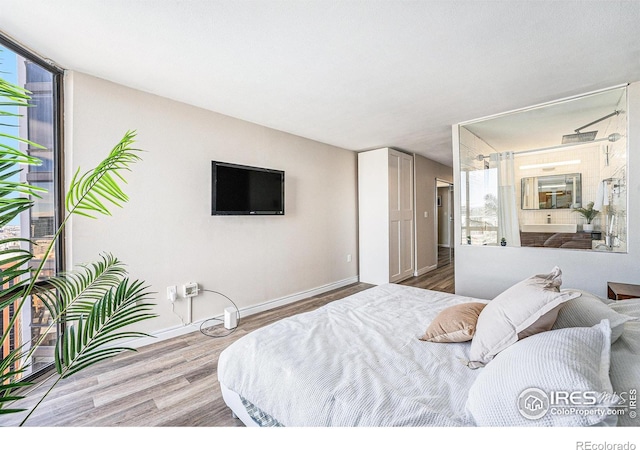 bedroom with wood finished floors and baseboards