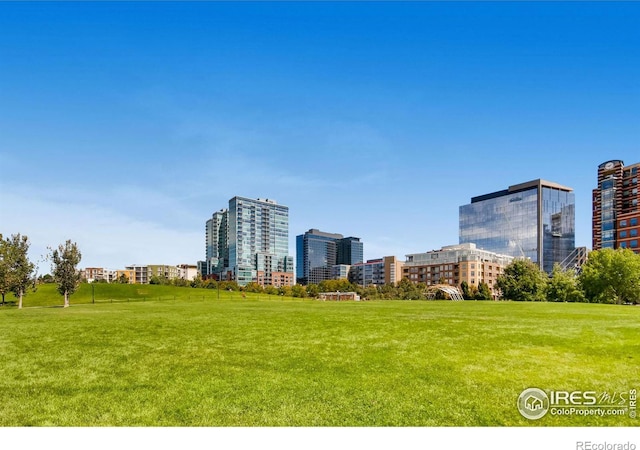 view of property's community featuring a view of city and a lawn