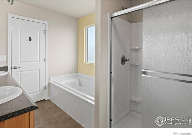 bathroom featuring a bath, tile patterned flooring, a stall shower, and vanity