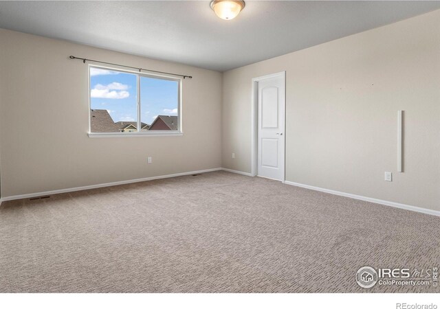 unfurnished room with visible vents, baseboards, and carpet