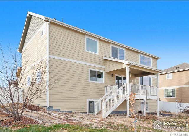 back of property featuring stairway and fence