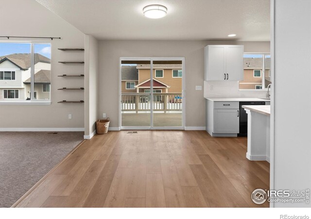 interior space with light wood-style floors, baseboards, and a sink