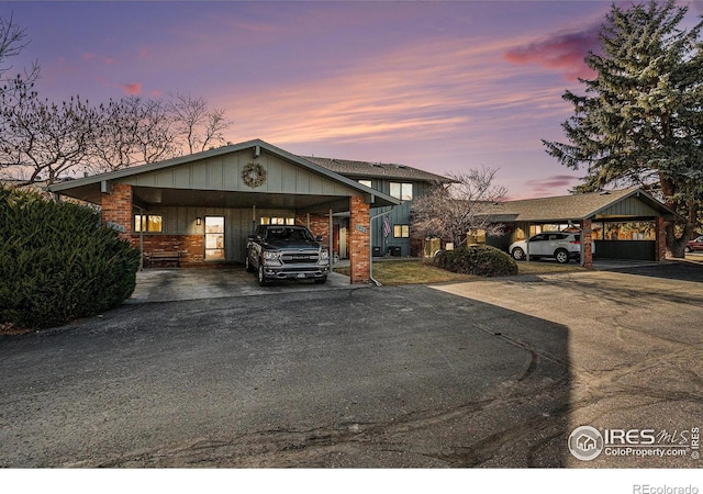 view of front of property featuring aphalt driveway, brick siding, and a carport