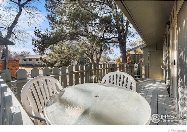 exterior space with a deck, outdoor dining area, and fence