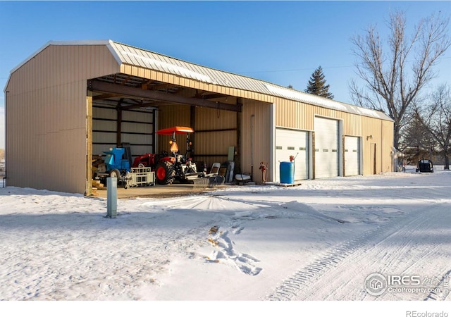 snow covered structure featuring an outbuilding