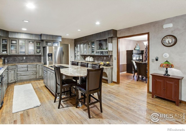 kitchen featuring light wood-style floors, gray cabinets, a kitchen island, and stainless steel refrigerator with ice dispenser