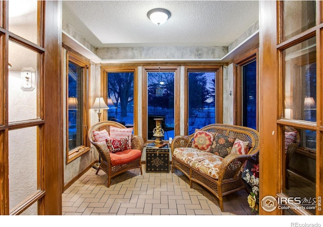 sitting room featuring a textured ceiling and brick floor