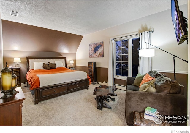 bedroom featuring carpet, visible vents, lofted ceiling, and a textured ceiling