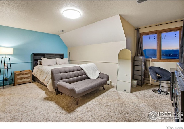 bedroom with carpet floors, lofted ceiling, visible vents, and a textured ceiling