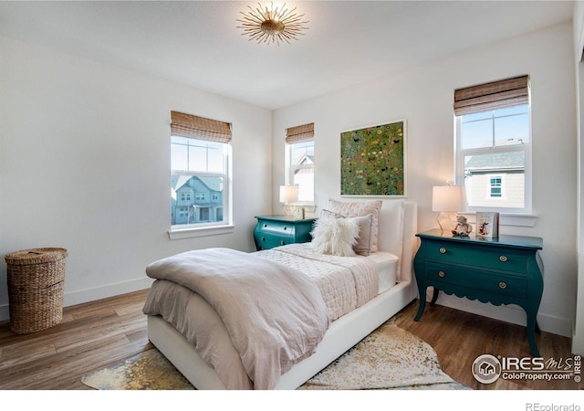 bedroom with wood finished floors and baseboards