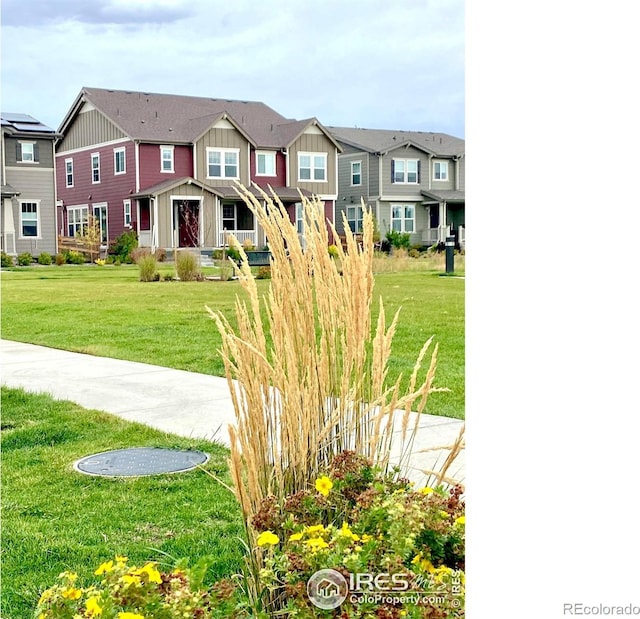 view of front of home featuring board and batten siding, a residential view, and a front yard