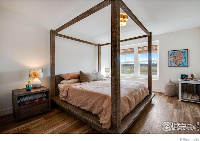 bedroom featuring hardwood / wood-style floors and baseboards