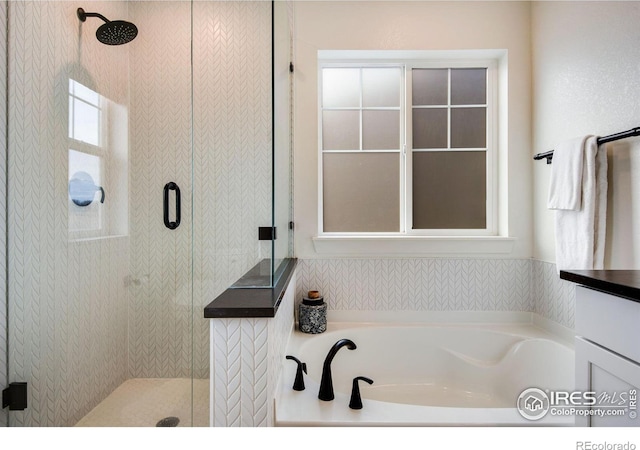 bathroom with a stall shower and a garden tub