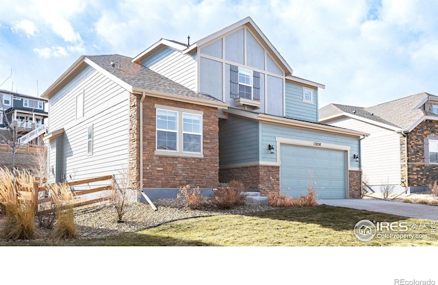 view of front of house with a shingled roof, a front yard, a garage, stone siding, and driveway