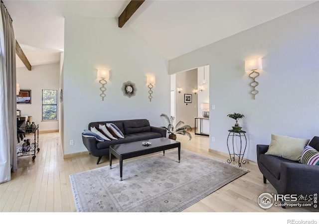 living room featuring light wood-type flooring, baseboards, high vaulted ceiling, and beam ceiling