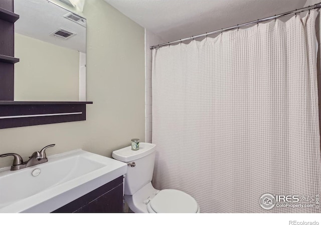 bathroom featuring toilet, visible vents, and vanity