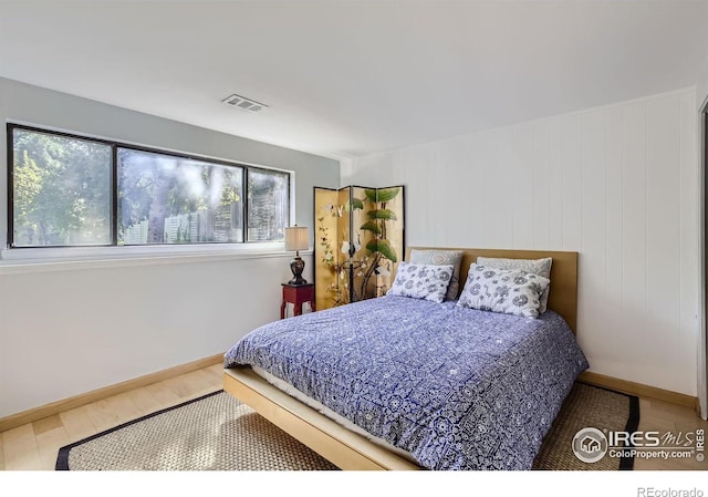 bedroom featuring wood finished floors, visible vents, and baseboards