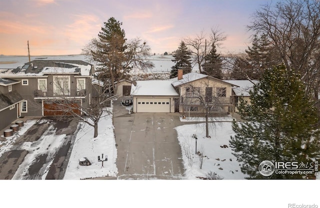 view of front facade with a garage and a chimney