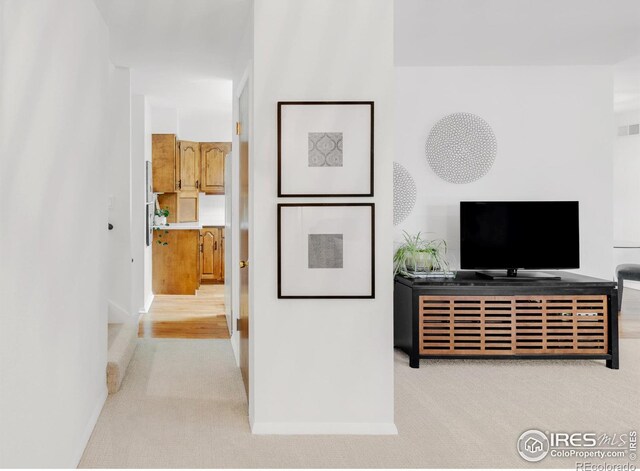 interior space featuring baseboards, visible vents, and light colored carpet