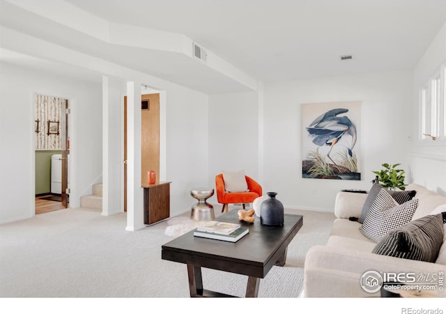 living room featuring light carpet, stairway, and visible vents