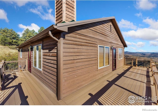 view of property exterior featuring a chimney and a wooden deck