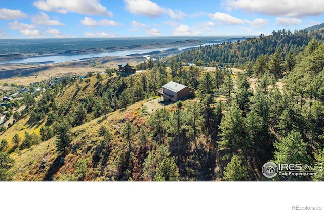 aerial view with a water view and a wooded view