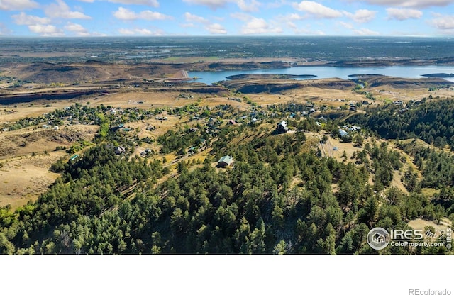 aerial view featuring a water view and a wooded view