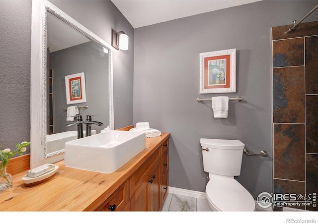 full bathroom featuring toilet, baseboards, walk in shower, and vanity