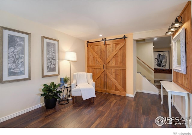 living area with a barn door, baseboards, wood finished floors, stairs, and recessed lighting