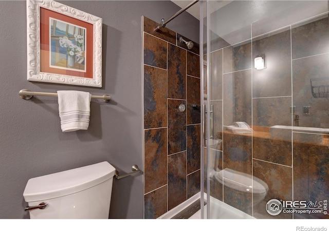 bathroom featuring a shower stall and toilet