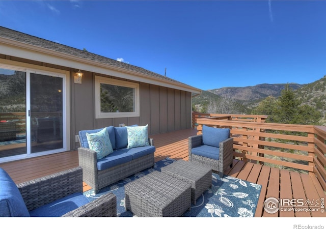 wooden deck with an outdoor hangout area and a mountain view