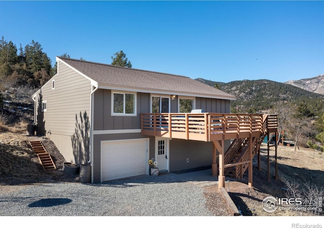 view of front of home featuring a garage, stairway, board and batten siding, and gravel driveway