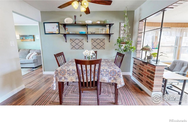 dining room with a ceiling fan, baseboards, and wood finished floors