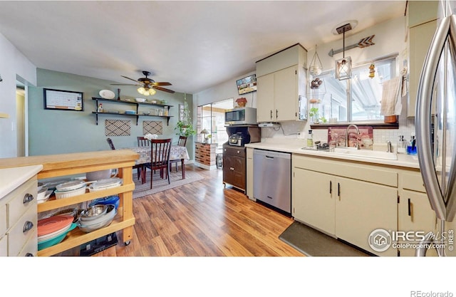 kitchen featuring stainless steel appliances, light countertops, a sink, and backsplash