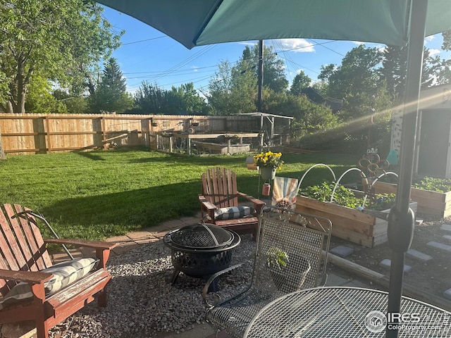 view of patio / terrace featuring an outdoor fire pit, fence, and a garden