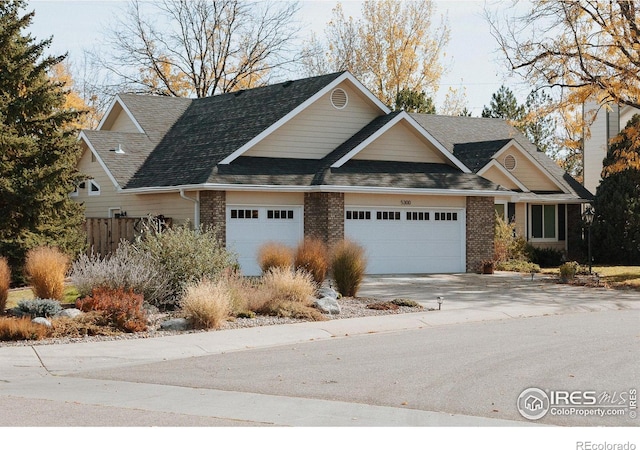 view of front of property with a garage, concrete driveway, brick siding, and roof with shingles