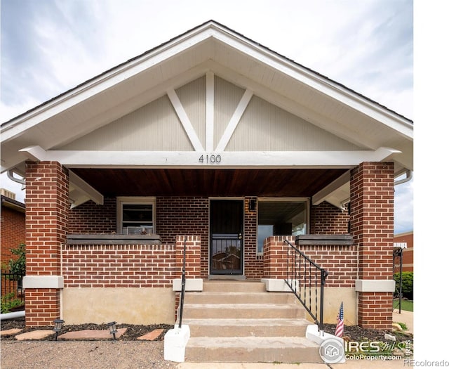 view of front of house featuring covered porch and brick siding